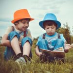 Boys reading in field